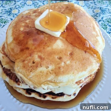 Stack of fluffy Cracker Barrel style buttermilk pancakes with butter and syrup dripping down