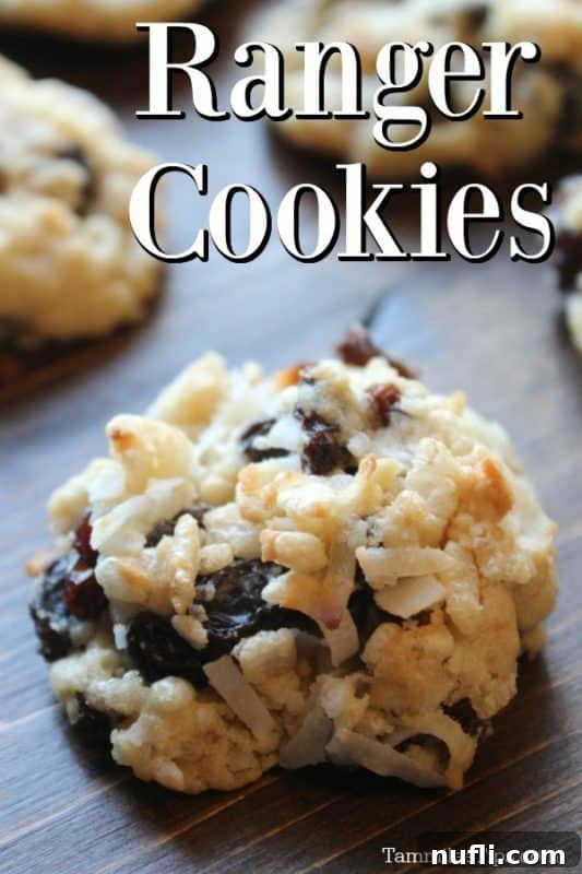 Delicious golden brown Ranger Cookies featuring visible Rice Krispies, raisins, and coconut, artfully arranged on a rustic wooden board.