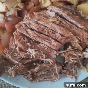 Alaskan Amber Slow Cooker Roast 3 Alaskan Amber Slow Cooker Pot Roast with roasted potatoes on a serving platter, ready to be enjoyed.