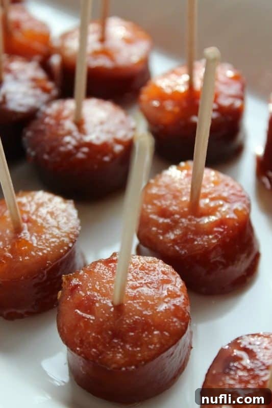 Individual slices of bourbon-glazed kielbasa with toothpicks inserted, ready for serving.