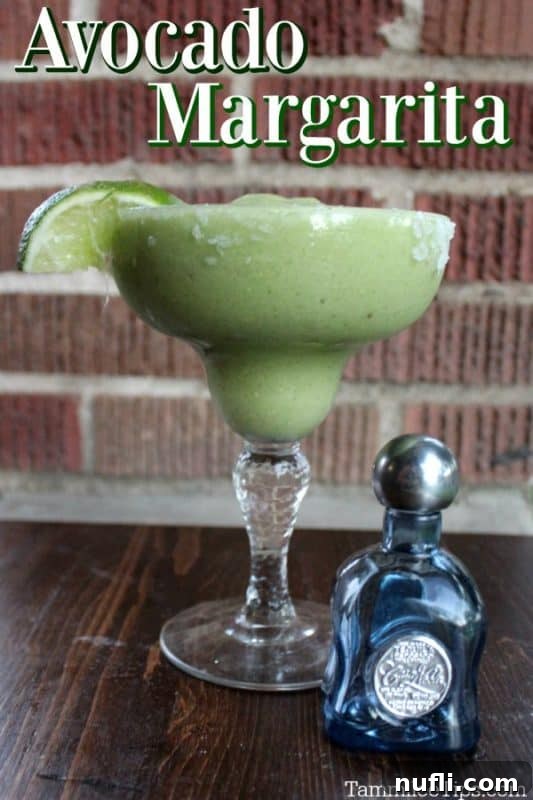 Crafting the Perfect Avocado Margarita 2 Creamy Avocado Margarita with a small bottle of tequila and lime garnish, ready to be enjoyed.