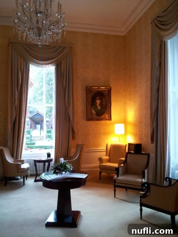 Elegant sitting room featuring a small table, comfortable chairs, and a dazzling crystal chandelier.