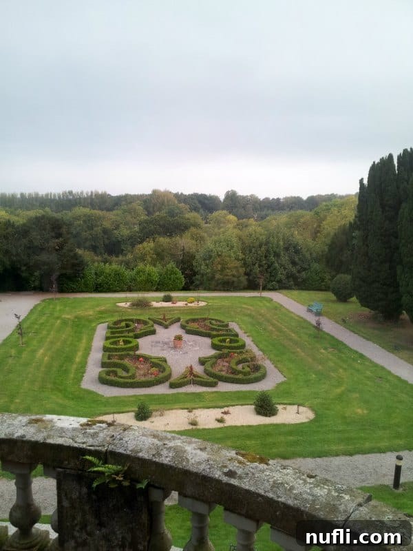 Serene view over a meticulously maintained garden adorned with classical sculptures.