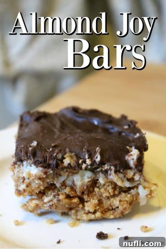 Homemade Almond Joy Bars 2 Delicious homemade Almond Joy Bars on a white plate, showcasing layers of crust, coconut, and chocolate.