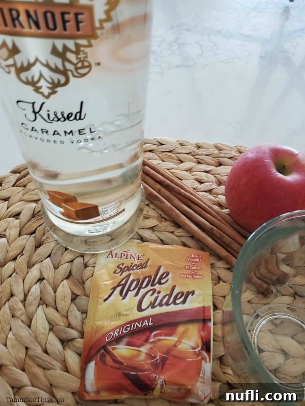 Indulgent Hot Caramel Apple Cider Cocktail 3 Kissed caramel vodka, apple cider mix packet, cup, cinnamon sticks, and an apple