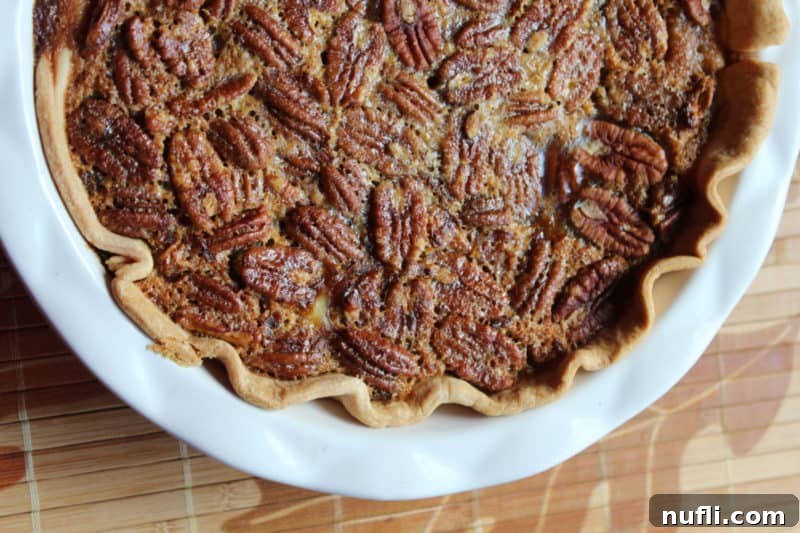 Sliced Pumpkin Pecan Pie showing off its distinct layers in a white pie dish