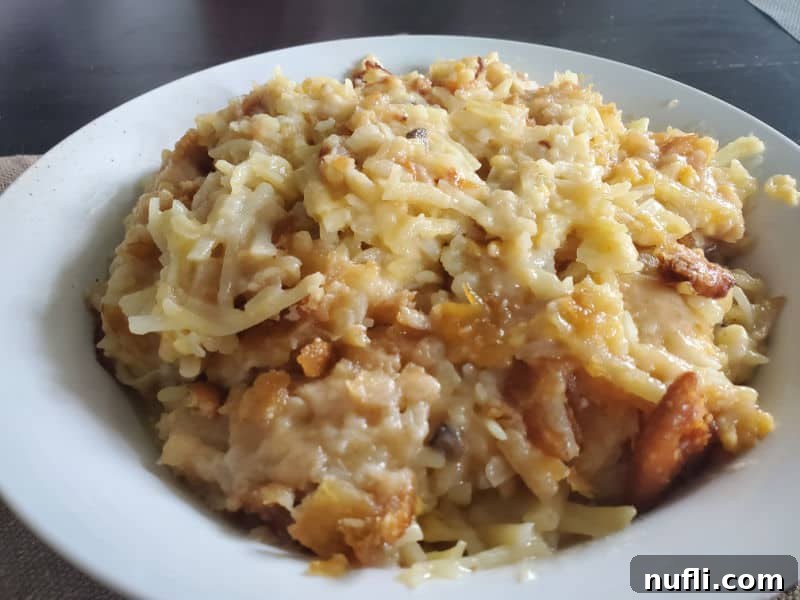 Creamy Slow Cooker Hashbrown Casserole 7 Cheesy hashbrowns served in a white bowl on a dark rustic table, ready to be enjoyed.