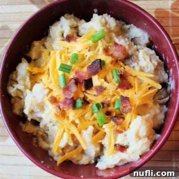 Crockpot Cheesy Potato Soup in a dark red bowl, a perfect representation of comfort food.