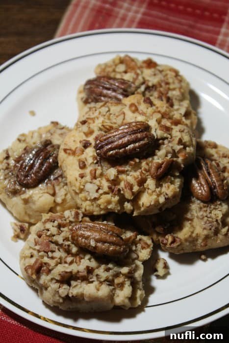 Irresistible Butter Pecan Cookies arranged on a pristine white plate, resting on a festive red napkin, ready for holiday celebrations.