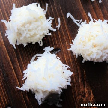 Close-up of Tropical No-Bake Truffles with coconut coating on a wooden board