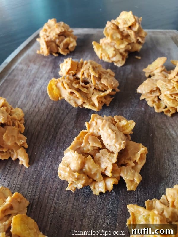 Close-up of freshly made butterscotch cornflake cookies on a wooden cutting board, showcasing their crunchy texture.