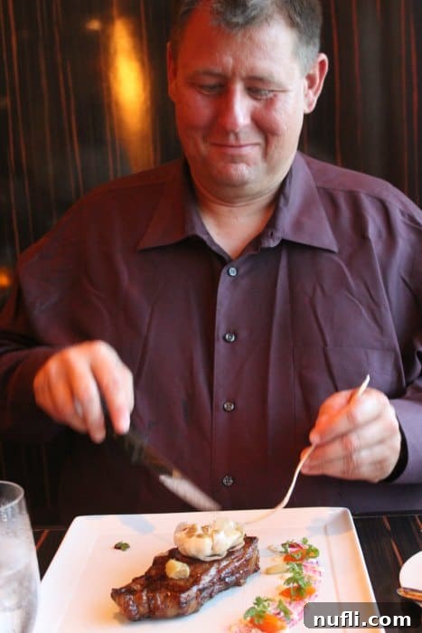 John smiling in anticipation, about to cut into a perfectly cooked steak at Fahrenheit 555
