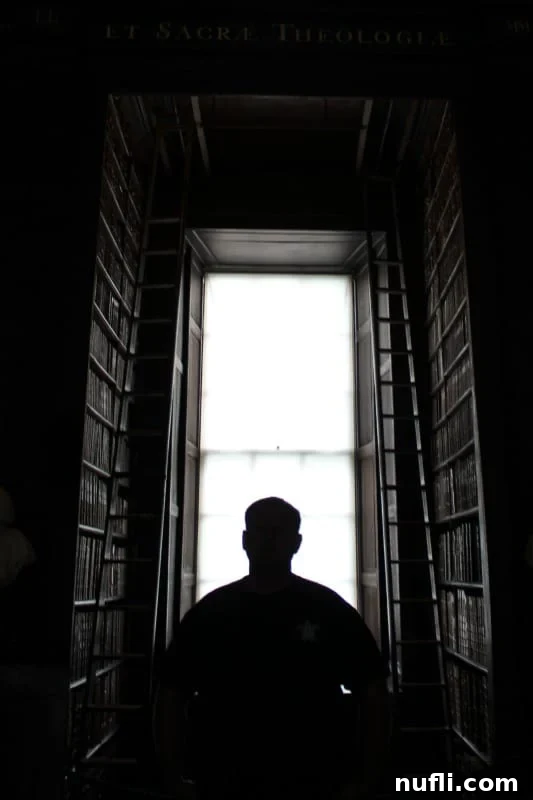 John standing in the Trinity Library