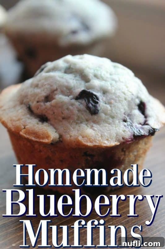 Homemade blueberry muffins next to a muffin on a cutting board. 