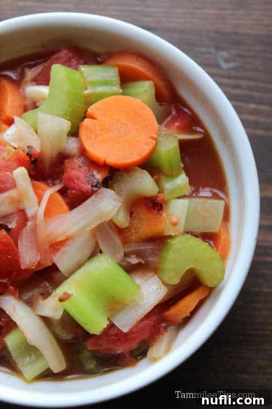 Weight Watchers Vegetable Soup in a white bowl on a wood board. 