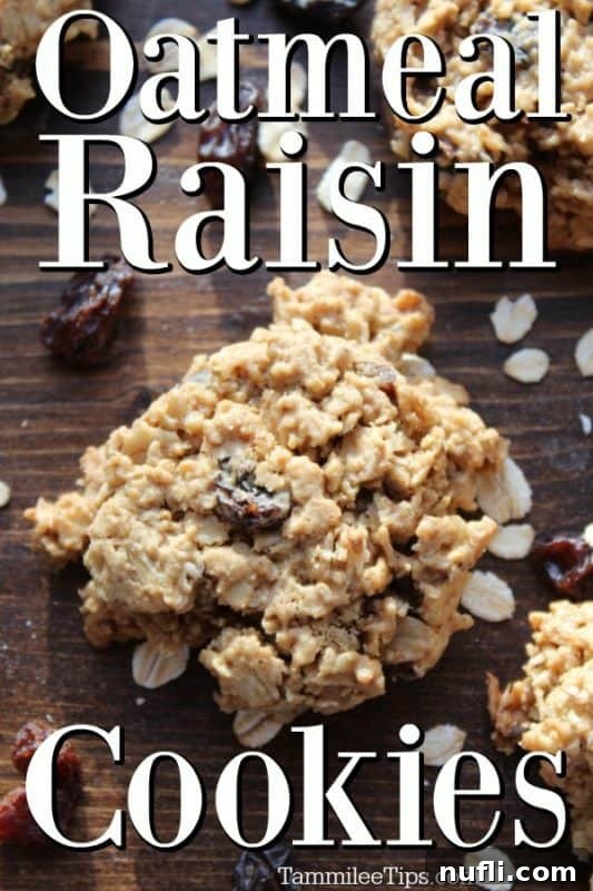 Freshly baked Oatmeal Raisin Cookies stacked on a wooden board