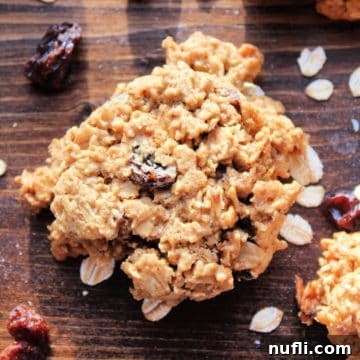 Healthy Oatmeal Raisin Cookies with oats and raisins on a wooden board