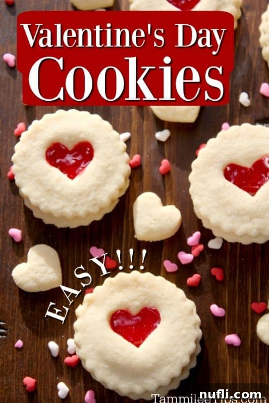 Valentine's Day Linzer Cookies with a red heart cutout in the middle, sprinkled with powdered sugar on a white plate.