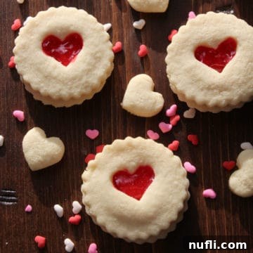 Red Heart Valentine's Day Cookies on a wood board with heart sprinkles
