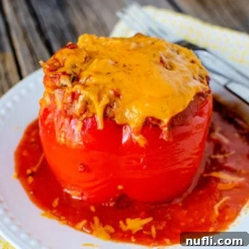 Crockpot Stuffed Pepper with cheese on a white plate next to a fork