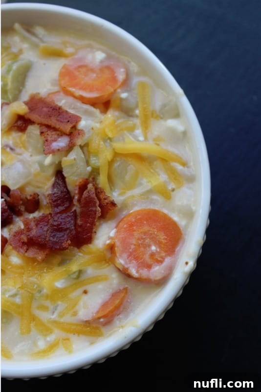 Hearty Crockpot Beer Cheese Soup 5 beer cheese soup garnished with bacon and cheese in a white bowl