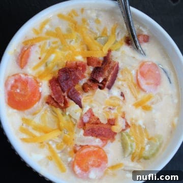 Hearty Crockpot Beer Cheese Soup 7 beer cheese soup with bacon garnish in a white bowl with silver spoon