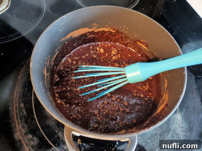 Cozy Slow Cooker Hot Chocolate 4 blue whisk in a pan of chocolate being mixed