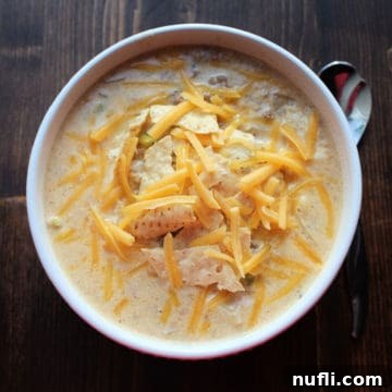 Crock Pot Cheeseburger Soup in a white bowl with a silver spoon