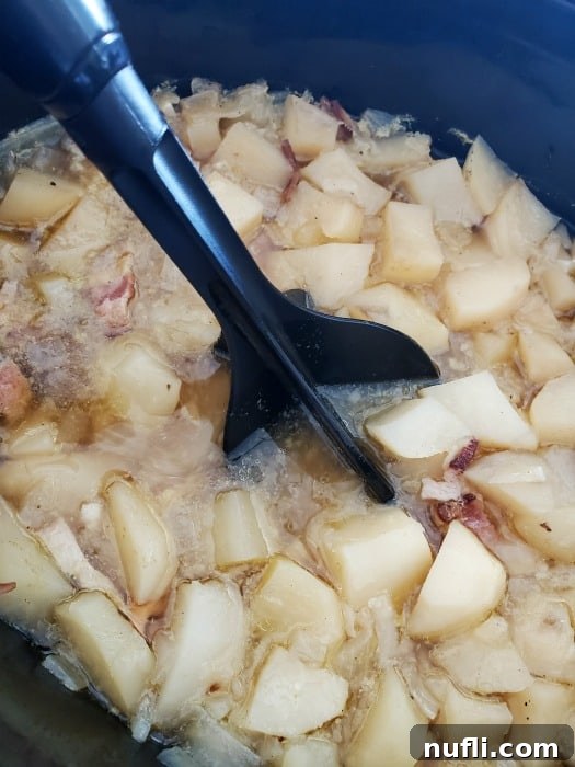 potatoes in a crock pot with a mix n chop breaking them up