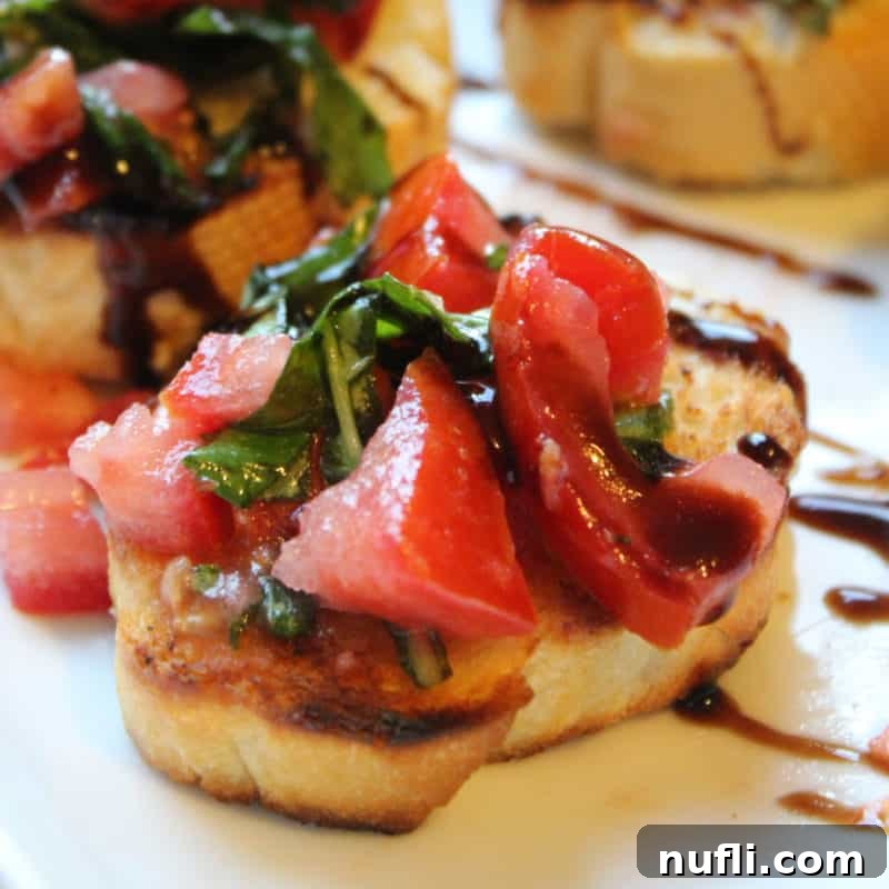 Effortless Entertaining: Simple Finger Foods for Any Party 16 Fresh Tomato Bruschetta artfully arranged on a crispy baguette slice, topped with vibrant basil, a quintessential Italian appetizer.