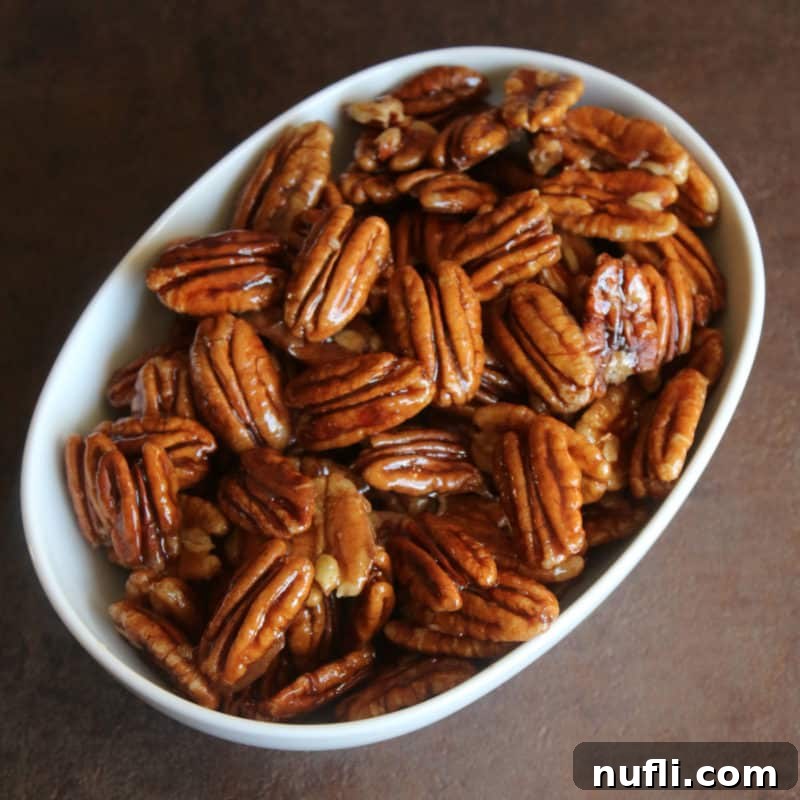 Effortless Entertaining: Simple Finger Foods for Any Party 24 Golden Honey Glazed Pecans in a white bowl, looking deliciously sweet and crunchy, perfect for snacking or garnishing.