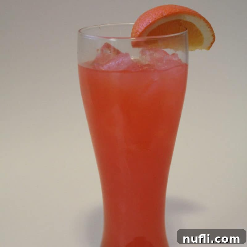 Sun-Kissed Sips: Over 35 Refreshing Summer Cocktails 19 Chili's Calypso Cooler in a tall glass with an orange garnish