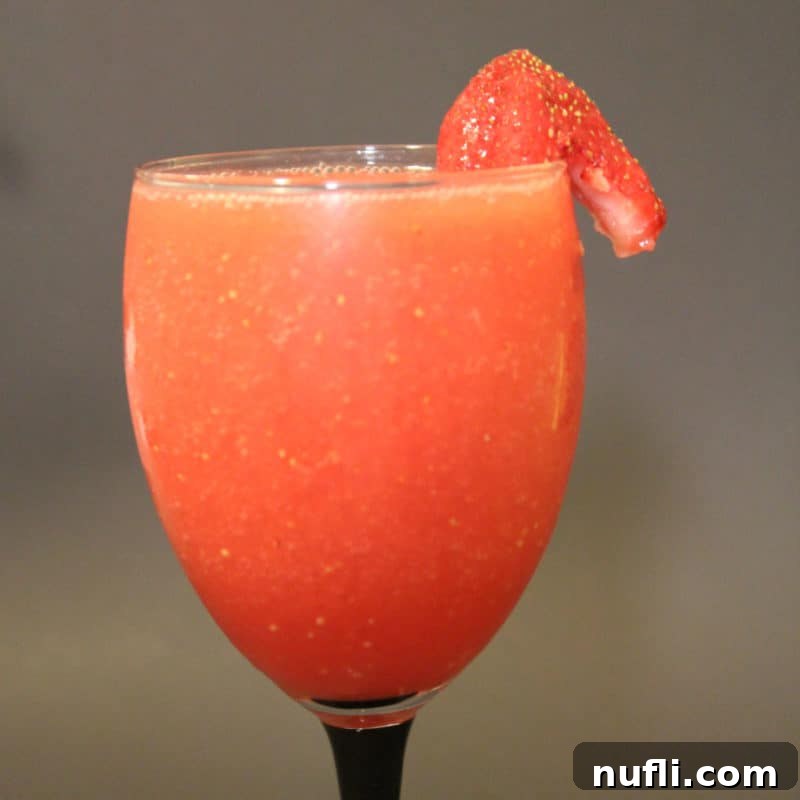 Sun-Kissed Sips: Over 35 Refreshing Summer Cocktails 25 Coral Reef cocktail with a strawberry garnish in a champagne glass