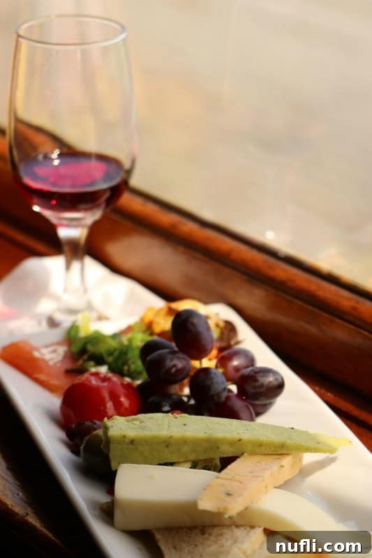 Napa Valley Wine Train Experiences 4 Wine glass accompanied by a plate of fruit and gourmet cheese