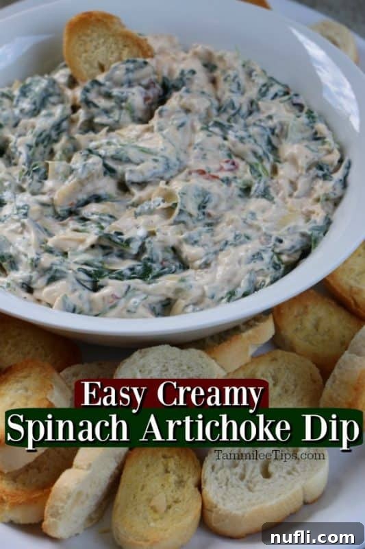 Creamy Spinach Artichoke Dip served in a white bowl with toasted baguette slices for dipping, perfect for a party appetizer.