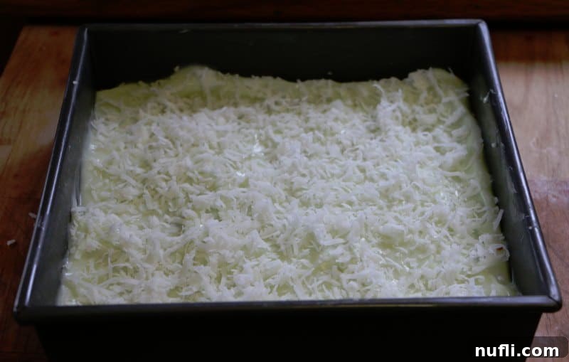 Ridiculously Easy Key Lime Bars 6 A close-up view of chilled Key Lime Pie Bars in a baking dish, topped with shredded coconut.