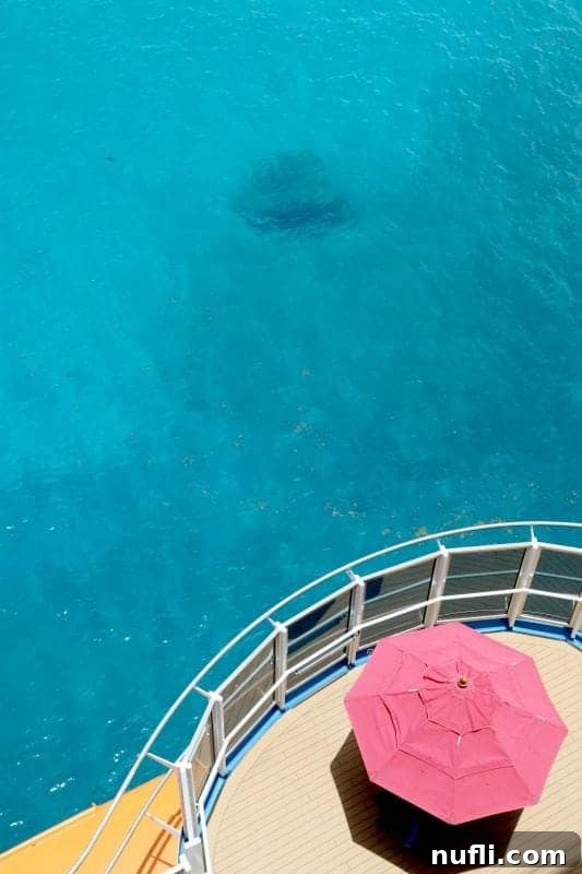 Looking down on the side of a cruise ship with a red umbrella 