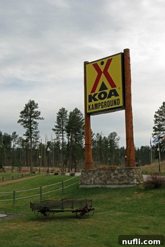 Classic KOA Kampground sign with a decorative wagon, welcoming visitors to the Mount Rushmore KOA