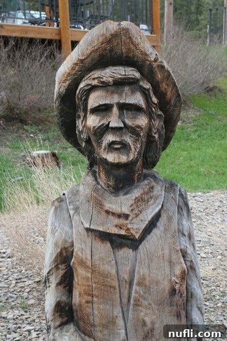 A carved wooden man with a hat, a decorative feature seen at the Mount Rushmore KOA campground