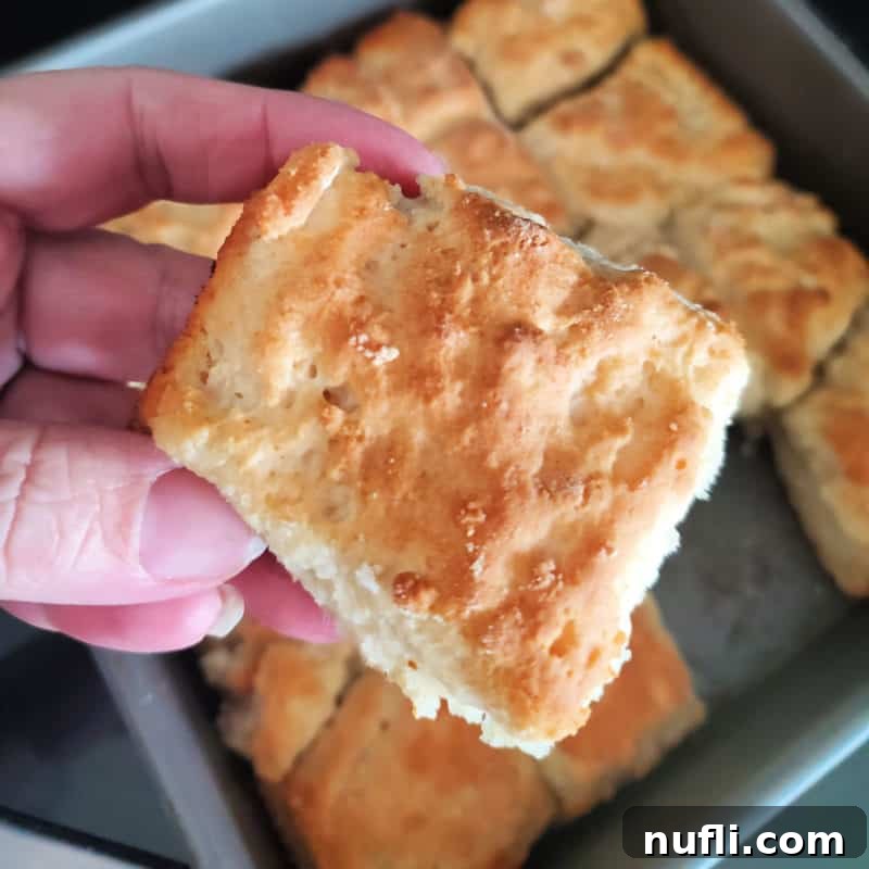 7 Up biscuit being held above a pan of biscuits