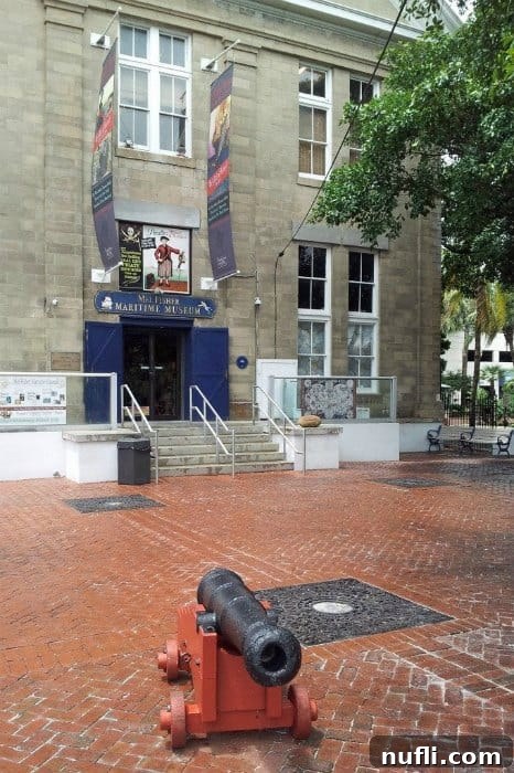 Exterior view of Mel Fisher Maritime Museum with brick courtyard and old cannon