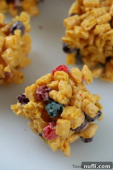 Neatly cut squares of Crunch Berry Treats arranged on a clean white plate, ready to be enjoyed.