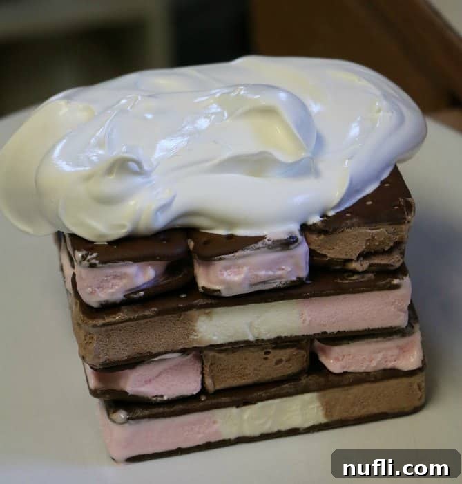 Ice cream sandwiches stacked, partially covered with whipped topping
