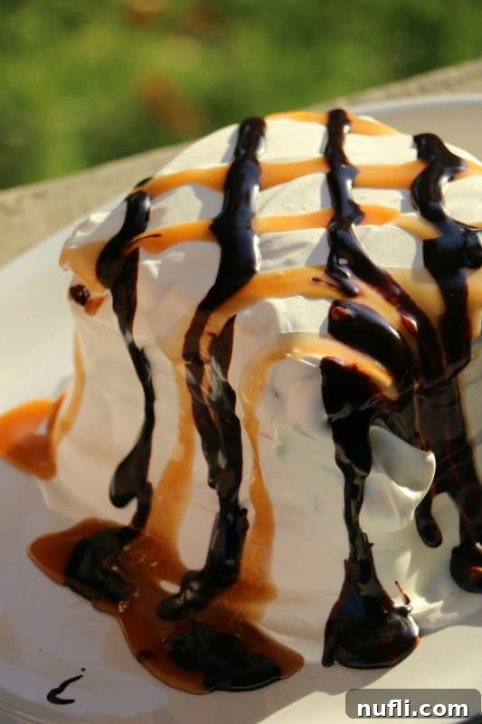 Chocolate caramel covered ice cream cake on a white plate, ready to serve