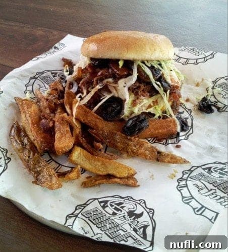 A delicious Guy's Burger Joint grinder burger on Carnival Breeze, piled high with toppings