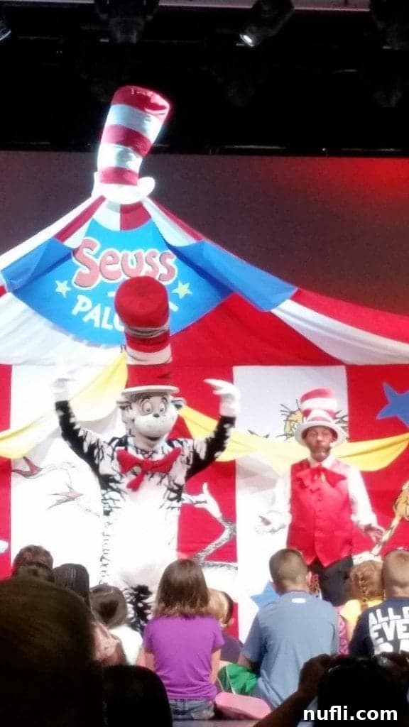 Cat in the Hat character interacting with children on stage in front of a Seuss-A-Palooza tent backdrop