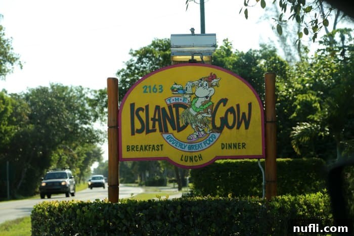 The whimsical sign for The Island Cow restaurant, featuring a cow with sunglasses