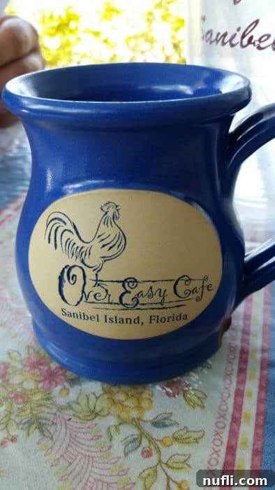 A blue mug with the logo of Over Easy Cafe