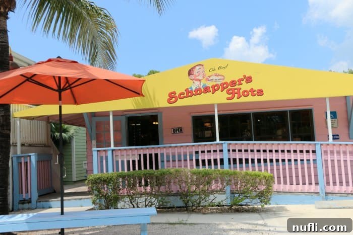 The vibrant sign for Schnapper's Hots above a pink building
