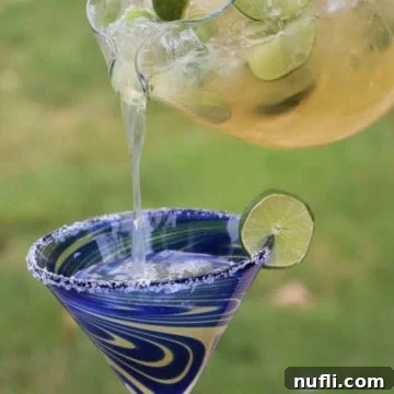 Whip Up Delicious Beer Margaritas 6 Beer Margaritas pouring from a glass pitcher into a margarita glass